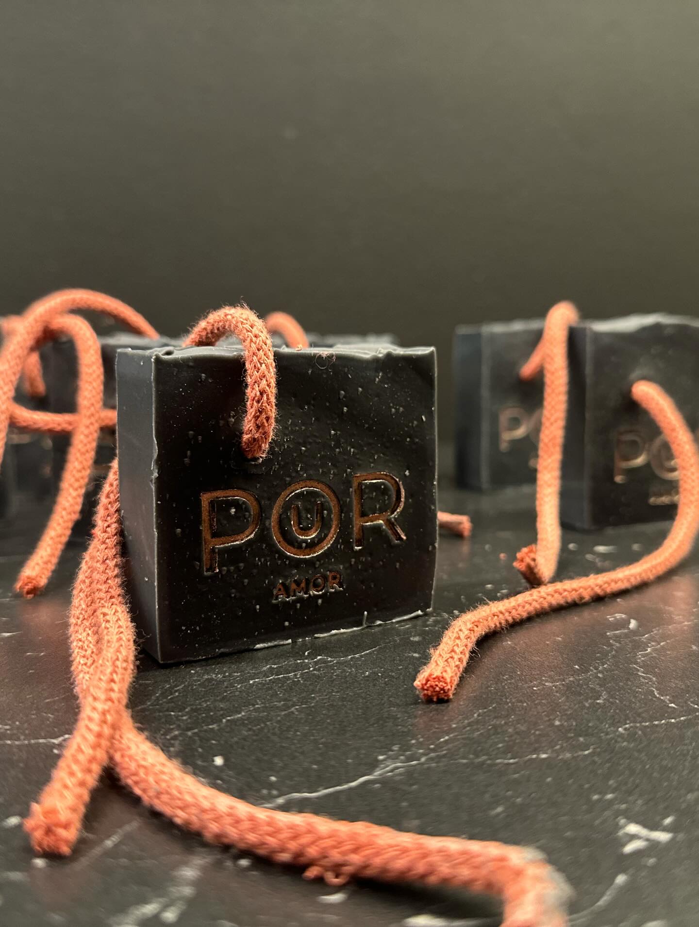 Sabonete natural PoUR AMOR preto com cordão em destaque